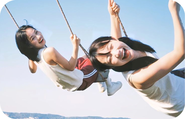 그네를 타며 웃는 두 친구의 기억